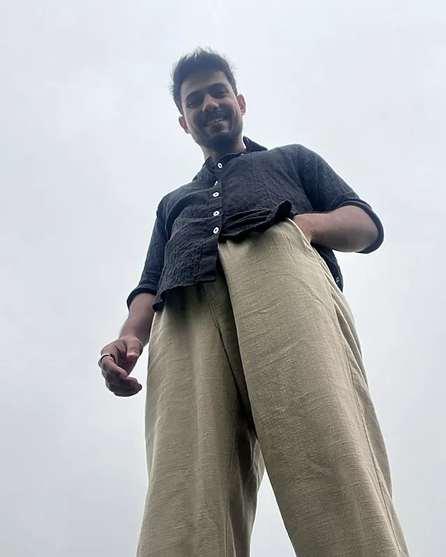 Aman photographed from below against a grey sky